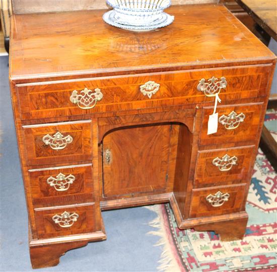 An early 18th century crossbanded kneehole desk, W.2ft 7in. D.1ft 7in. H.2ft 7in.